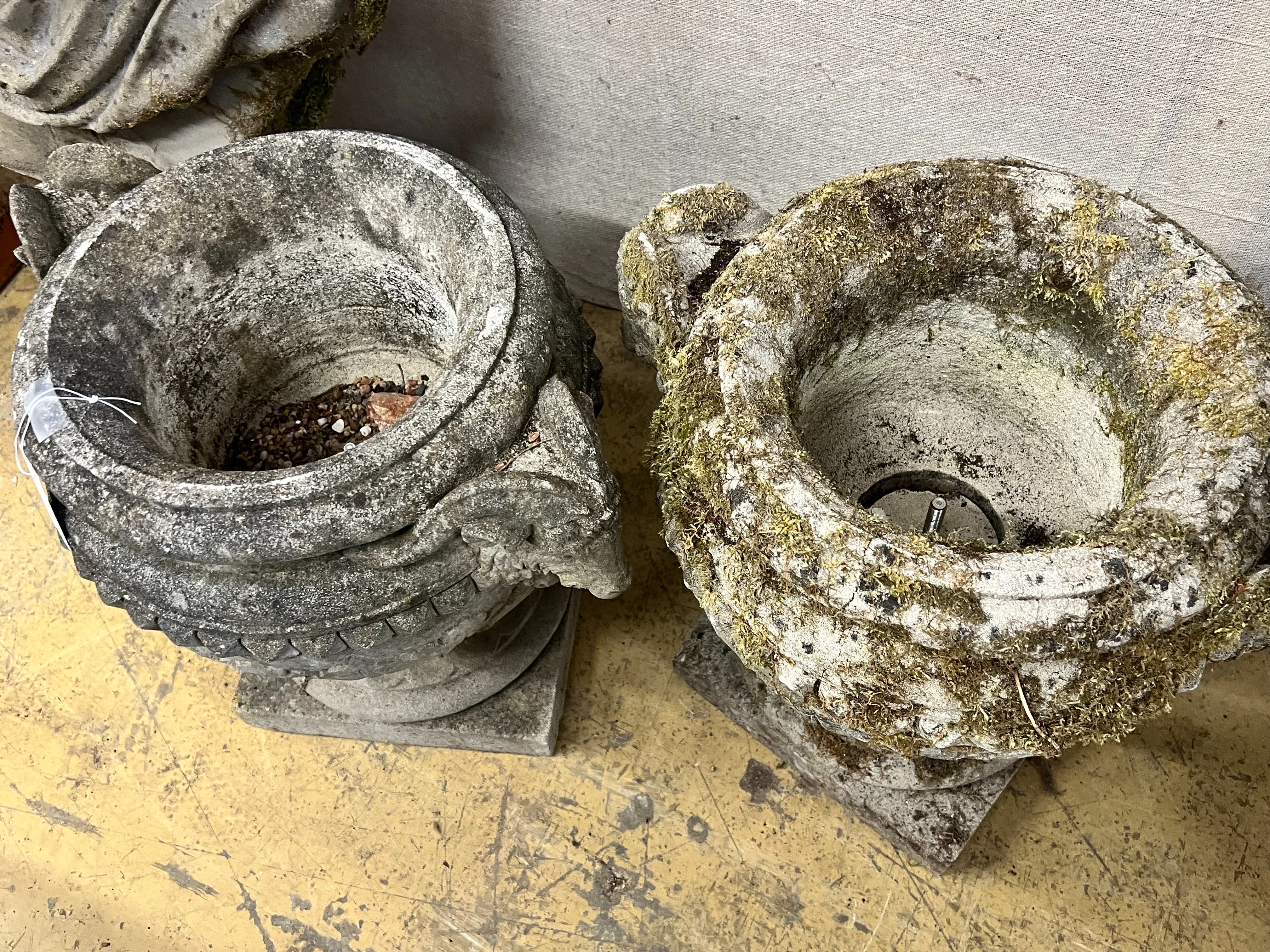 A pair of reconstituted stone circular rams head garden urns, width 50m height 46cm
